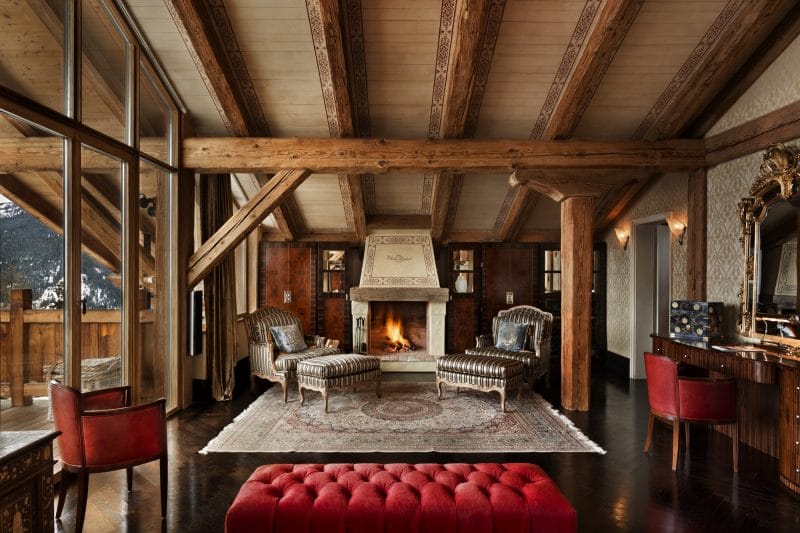 Switzerland's Best Ski Chalet nominee: The lush master bedroom provides incredible private space. Two lounging chairs sit alongside the bedroom's private fireplace