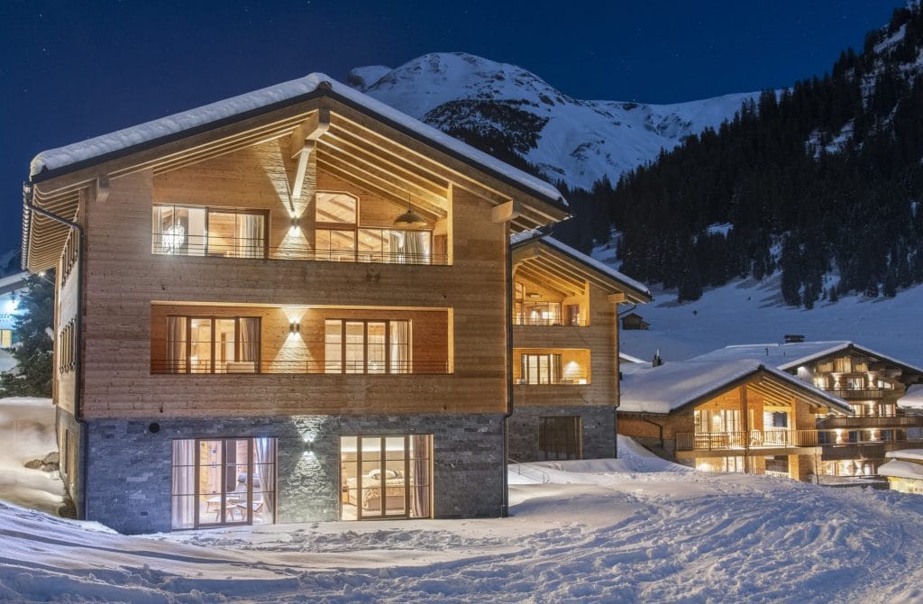 A snowy night exterior image of Chalech Residence for a ski holiday in Lech