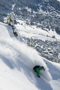 Skier kicking up fresh powder over Verbier